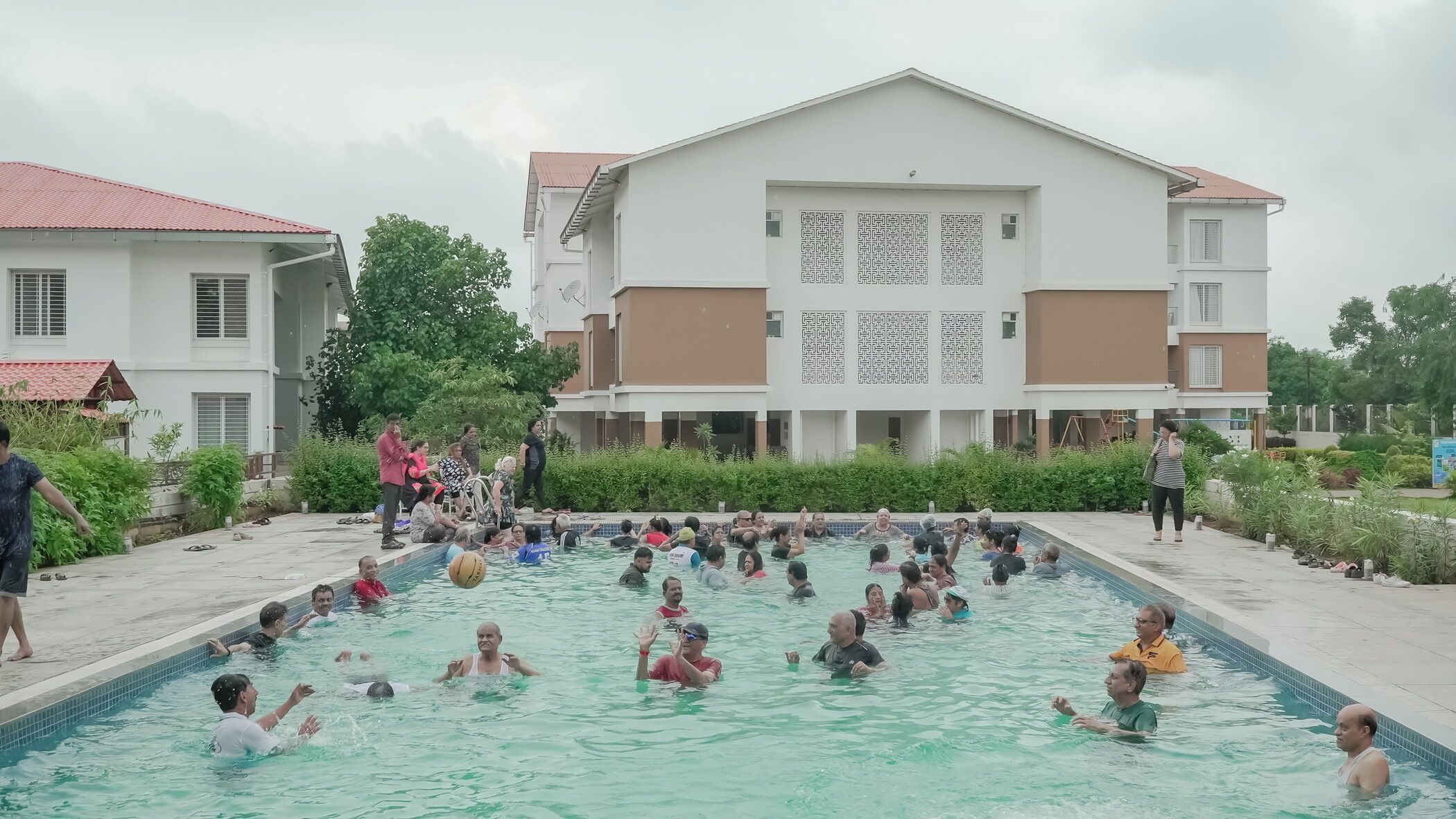 Ein Schwimmbeckenbereich mit mehreren Personen beim Schwimmen und beim Zusammensein.