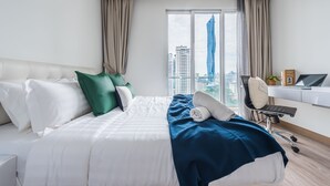 Moderni hotellihuone, jossa on suuri sänky, työpöytä ja näkymä korkeaan rakennukseen.