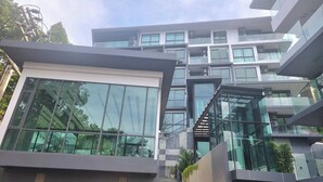 A modern multi-story building with large glass windows and a staircase leading to an upper level. - B303- 1 Bedroom Condo With Sea View, Ao Nang Beach (Krabi)