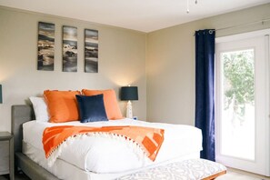 A bedroom with a bed, a nightstand, a lamp, and a window with curtains. - Anastasia Island Getaway - Summer vibes! (St. Augustine Beach)