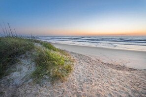Enjoy a serene beach experience with gentle waves and unspoiled dunes.