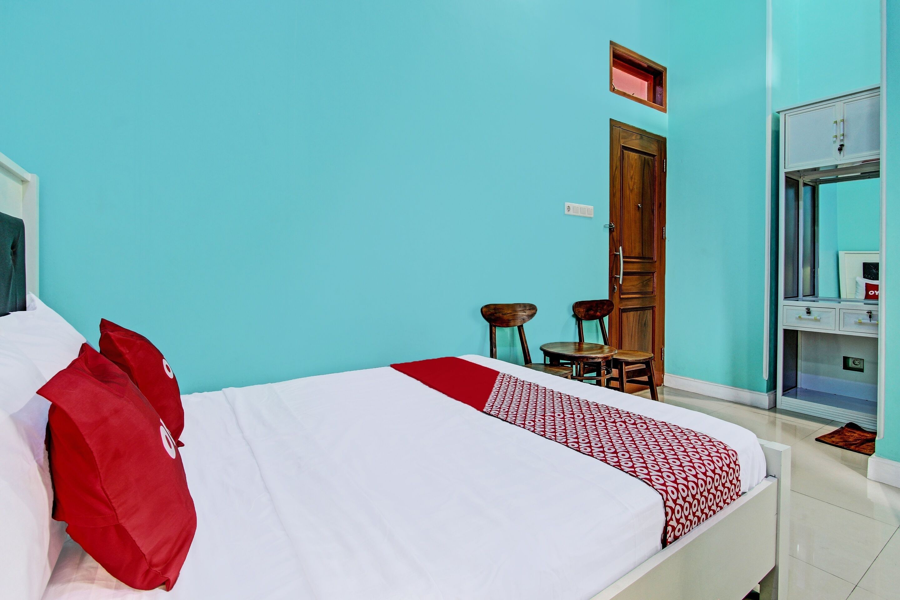 Une chambre d’hôtel avec un lit, un bureau et une armoire.