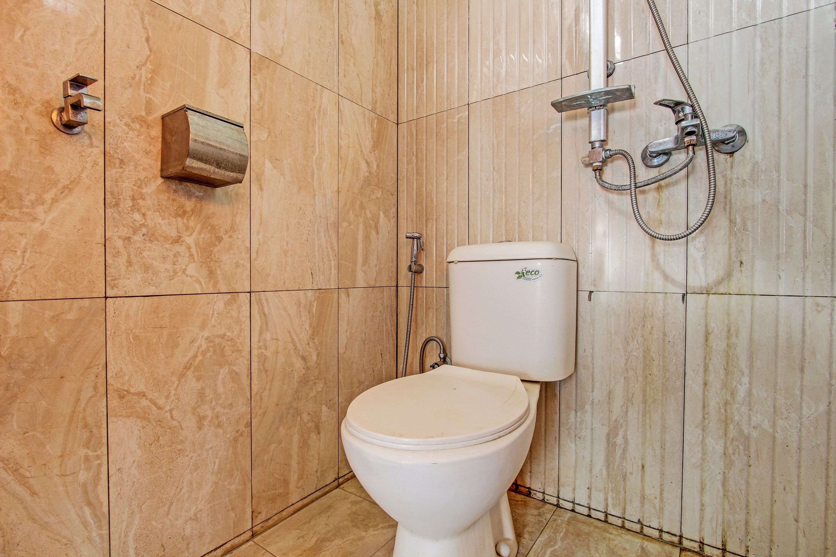 Une salle de bain comprenant des toilettes, une douche et un lavabo fixé au mur.