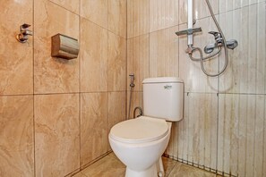 A bathroom with a toilet, a shower, and a wall-mounted sink. - Hotel O Amole Homestay Syariah (Cilacap)