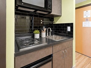 A kitchen with a stove, microwave, and sink.