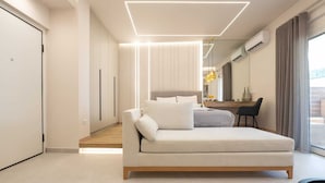 Une chambre moderne équipée d’un canapé, d’un bureau et d’un appareil de climatisation.