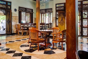 A restaurant with a checkered floor, wooden furniture, and stained glass windows.