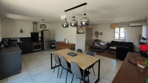 Une cuisine moderne avec un coin repas, un canapé et une table basse.