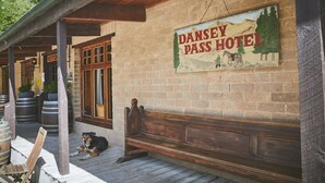 A wooden bench outside a building with a sign reading "DANSEY PASS HOTEL". - Danseys Pass Hotel (Kyeburn Diggings)