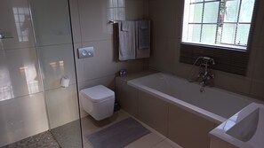 A modern bathroom with a toilet, sink, and bathtub. - SnL Guesthouse at Visarend (Nkomazi)