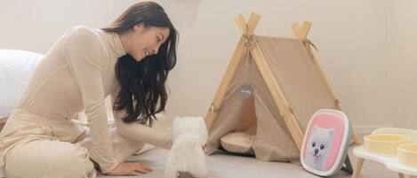 A person in a room with a tent-like structure and a small table with bowls.