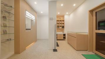 A hotel reception area with a reception desk, a self-check-in kiosk, and a reception sign.