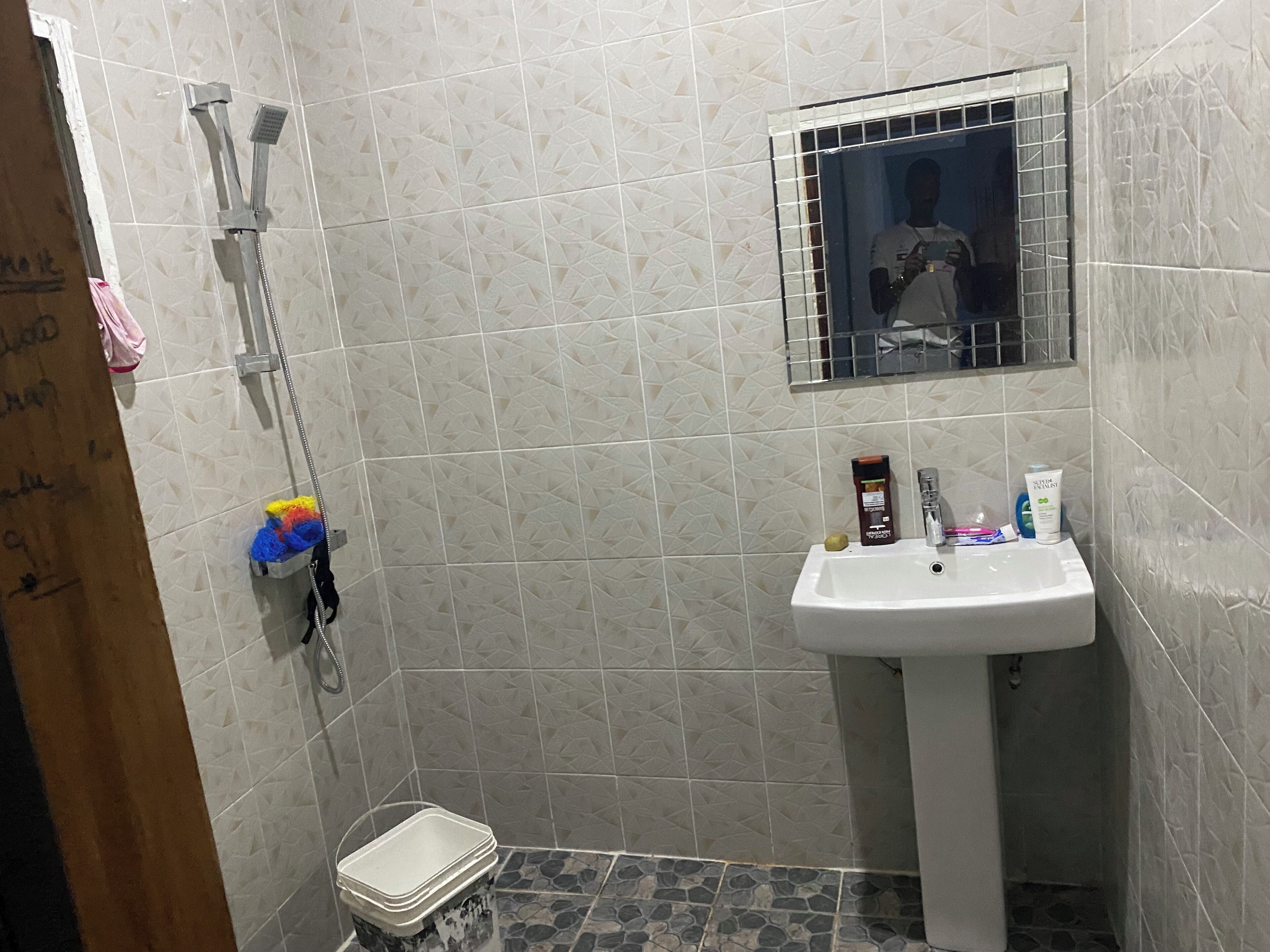 A bathroom with a shower, a sink, and a mirror.