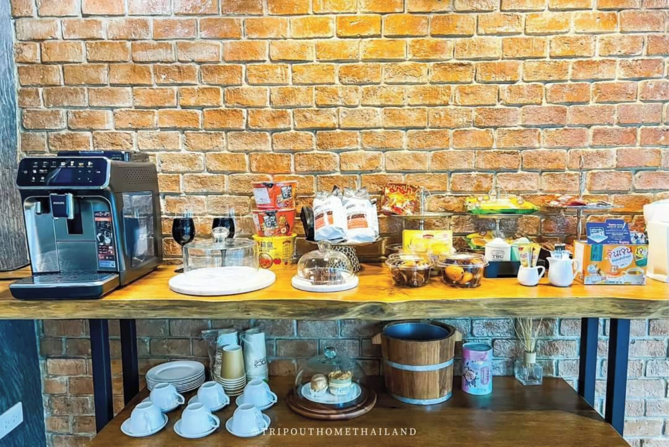 Una barra de desayuno con una máquina de café, diferentes alimentos y aderezos.