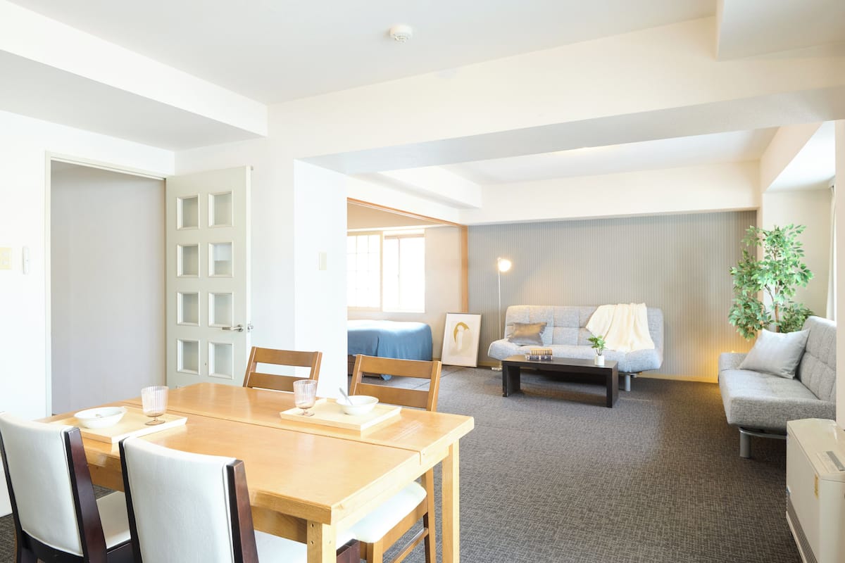 A modern hotel room with a dining area, a sofa, and a small table.
