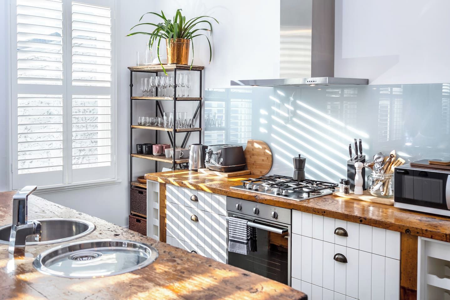 A modern kitchen with a wooden countertop, stainless steel appliances, and a built-in oven.