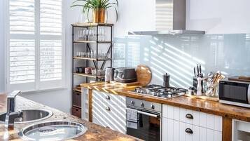 A modern kitchen with a wooden countertop, stainless steel appliances, and a built-in oven.