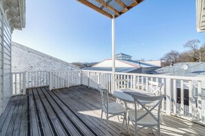 A covered outdoor deck with a white railing, a table, and two chairs. - Altitude Apartment, Martinborough (Martinborough)