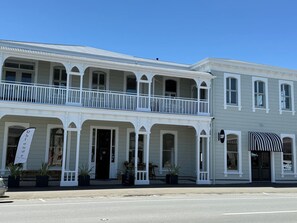 A two-story building with a balcony, arched windows, and a signboard. - Altitude Studio Apartment (Martinborough)