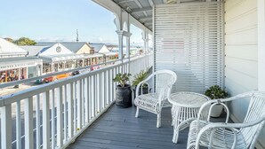 A balcony with white wicker chairs and a potted plant. - Altitude Studio Apartment (Martinborough)