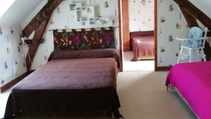 Une chambre avec un grand lit, une chaise et une petite table.