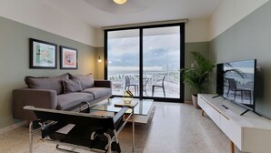 Una sala de estar moderna con sofá, mesa de centro y televisor.