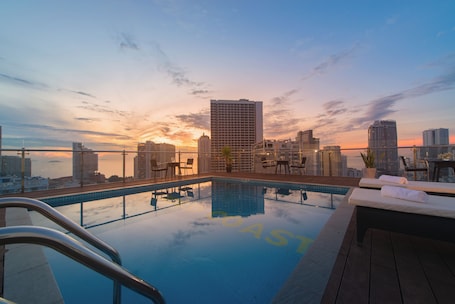 Una piscina al aire libre, sillones reclinables de piscina
