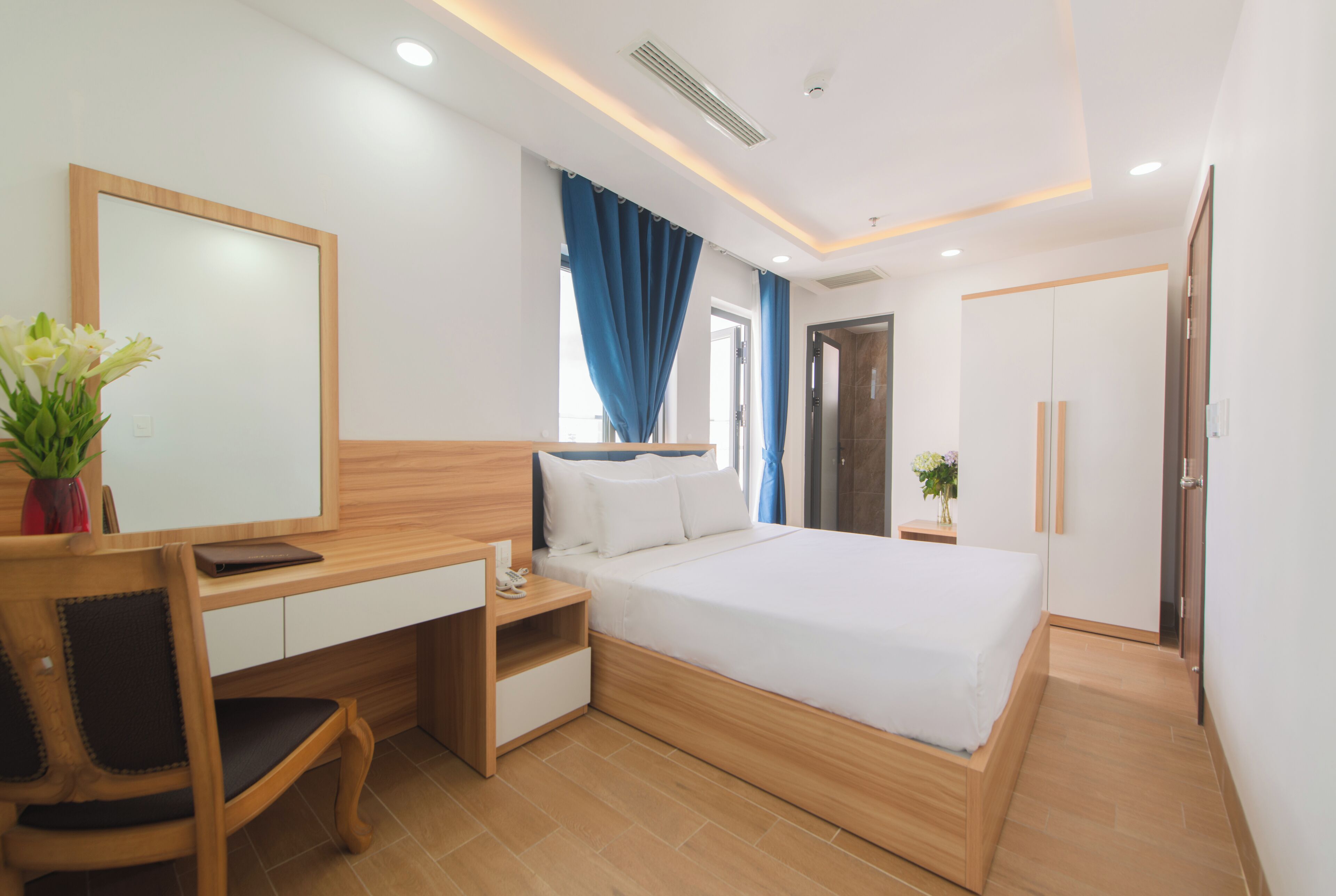 Un dormitorio moderno con un escritorio de madera, una cama y un armario.