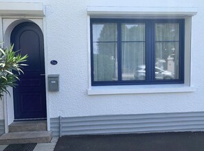 Ein Gebäude mit einer schwarzen Tür, einem Fenster mit weißem Rahmen und einem Schild mit der Nummer 5.