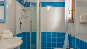 A bathroom with a shower, two toilets, a sink, and a mirror. - Stunning Residence Bouganvillage Studio (Budoni)