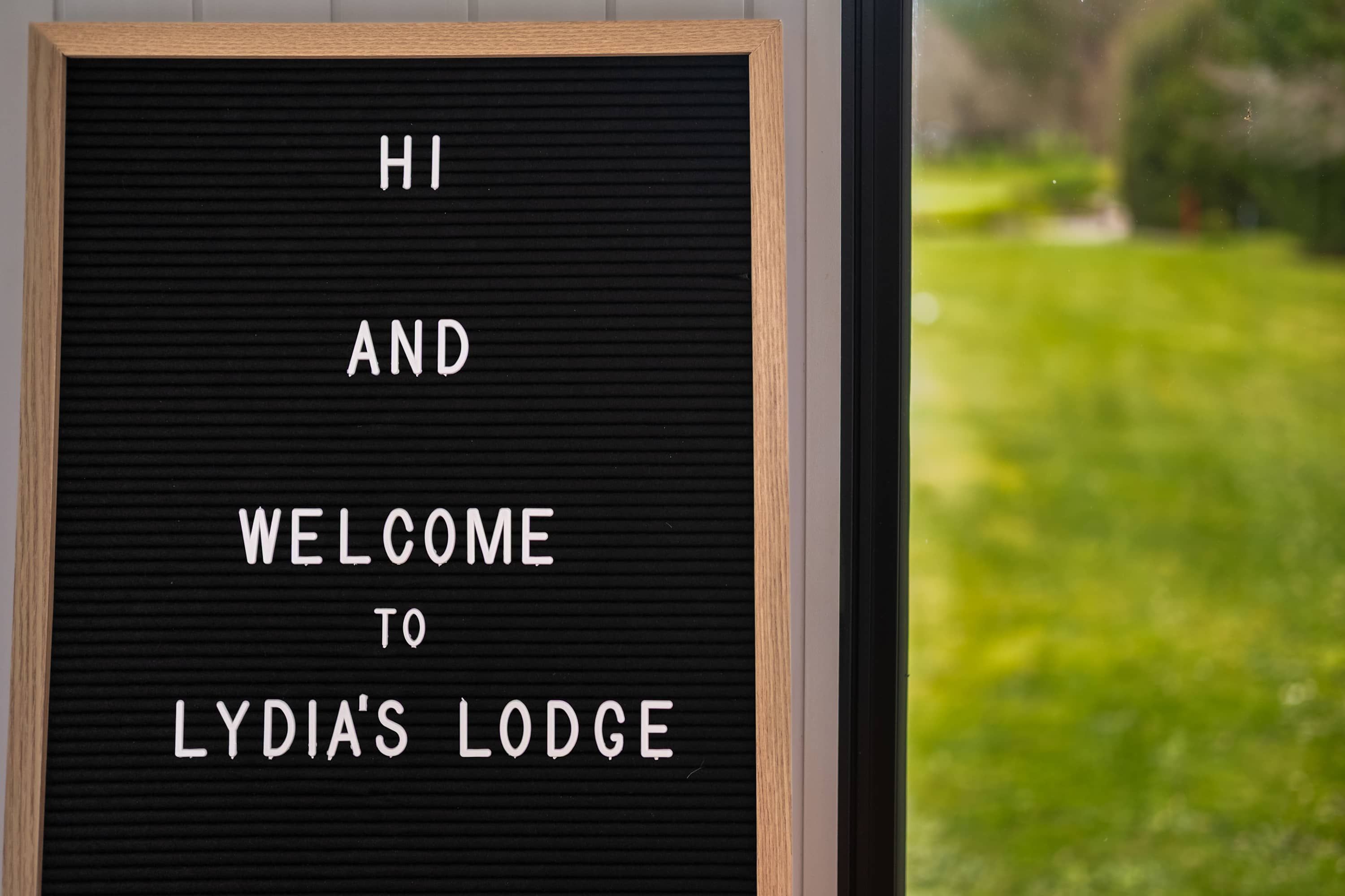 A sign with the text 'HI AND WELCOME TO LYDIA'S LODGE'.