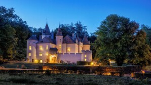 Un edificio que recuerda a un castillo, con múltiples torres y una entrada bien iluminada.