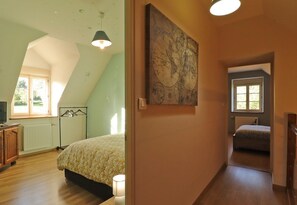 A bedroom with a bed, a hanging light fixture, a radiator, and a window. - Bright house with enclosed garden, spa, near Perche (Le Pin-la-Garenne)
