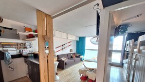 Eine moderne Wohnung mit Küche, Essbereich und Wohnzimmer. Sie verfügt über Holzböden, ein Sofa und einen Esstisch.