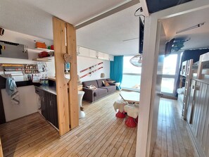 Relax in this inviting living space with a sofa, small table, and kitchen area.