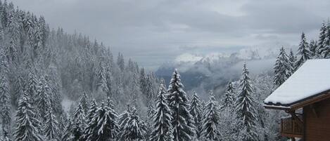 A snowy mountain landscape with a cabin and a balcony.