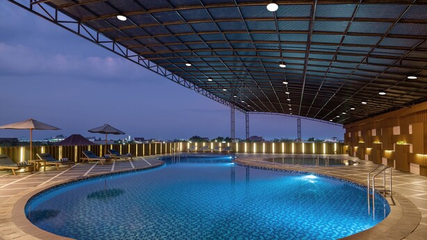 A large indoor swimming pool with a tiled floor and a covered roof structure.
