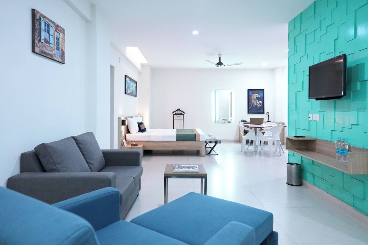 A modern living room with a sofa, a coffee table, and a dining area with chairs and a table.