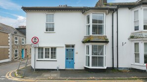 A white two-story house with a blue door, numbered 38, and a no parking sign. - Floyd’s, St Ives – Sleeps 8 – Dog Friendly – Off-Site Parking (St Ives)