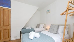 A bedroom with two beds, wooden furniture, and a bunk bed. - Floyd’s, St Ives – Sleeps 8 – Dog Friendly – Off-Site Parking (St Ives)
