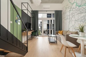 A modern interior with a staircase, a dining area, and a view of a building through large windows.