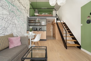 A modern apartment with a loft bedroom, a dining area, and a staircase.