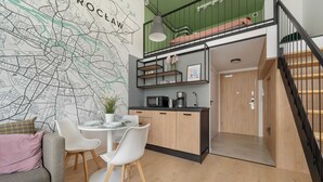 Une cuisine moderne avec un coin repas, un escalier et une carte accrochée au mur.