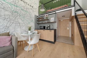 A modern kitchen with a dining area, a staircase, and a map on the wall.