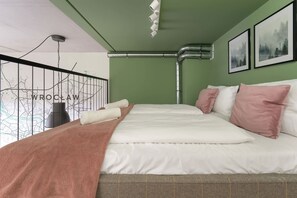 A neatly made bed with pillows, a blanket, and a headboard. - Comfortable Studio | Balcony | Close to Airport (Wrocław)