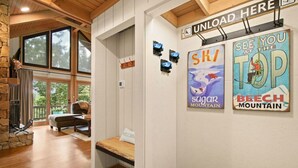 Un cuarto acogedor con chimenea de piedra, una cama y vistas al exterior. Hay dos carteles en la pared que promocionan actividades de esquí y snowboard.