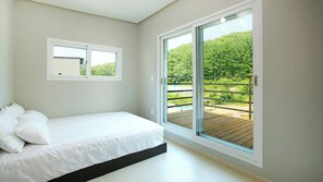 A bedroom with a bed, a window, and a view of a balcony. - Hongcheon Stone Brown Pension (Hongcheon)