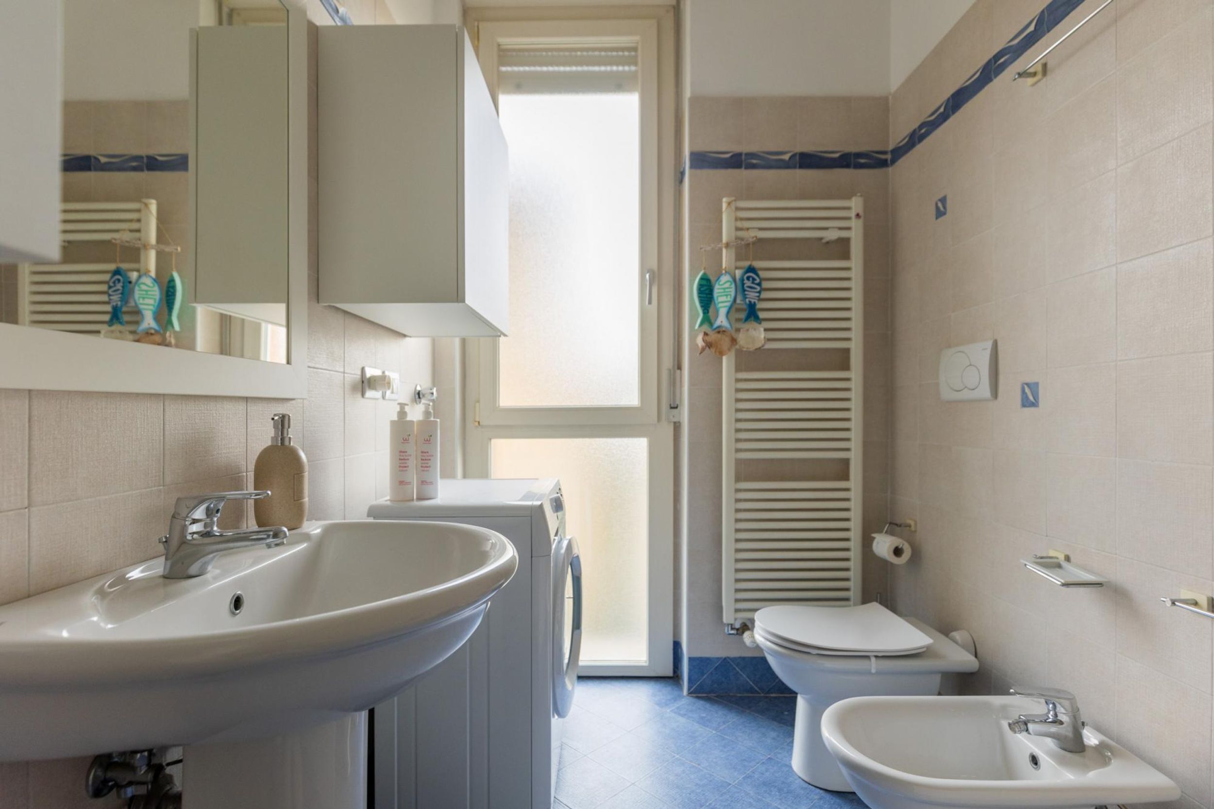 Ein Badezimmer mit Waschbecken, Bidet, Toilette und Spiegel.