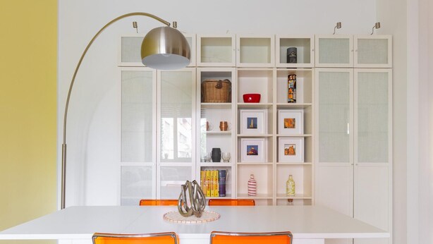 A dining area with a white table, orange chairs, and a modern lamp. - Casa Limone by Wonderful Italy (Bologna)