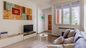 A modern living room with a flat-screen TV, a coffee table, a sofa, and a bookshelf. - Casa Limone by Wonderful Italy (Bologna)